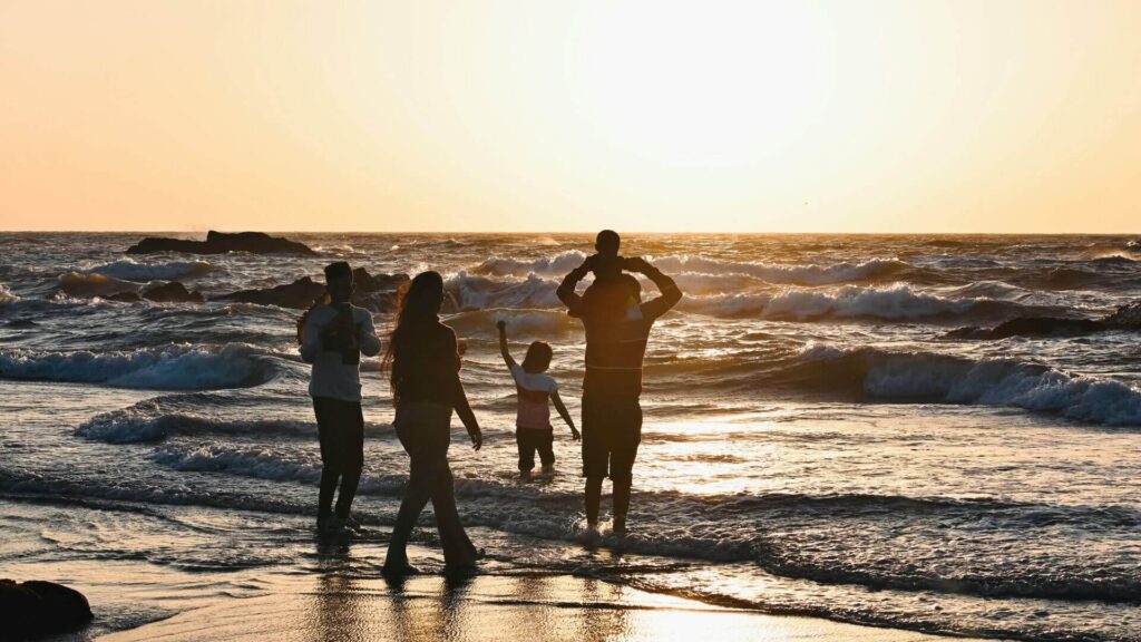Gezin bekijkt de zonsondergang aan zee