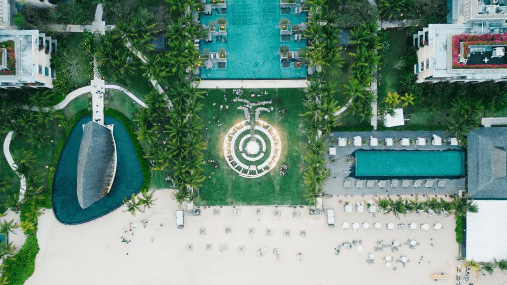 Luxe zwembad aan het strand omringd door palmbomen en weelderig groen.