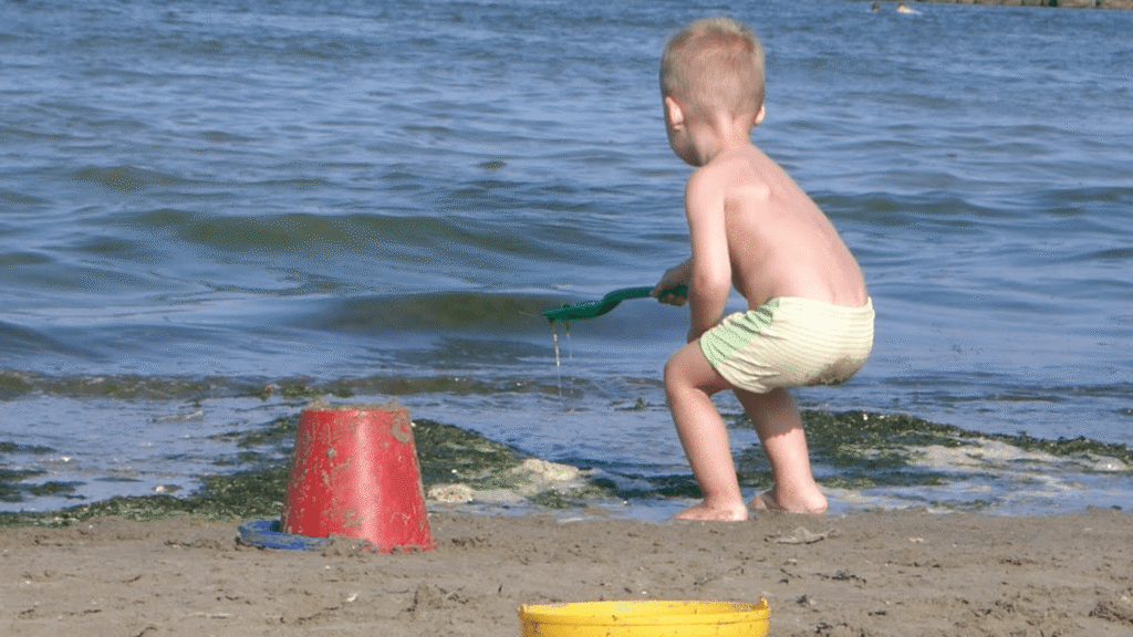 Kind speelt in het zand tijdens een kindvriendelijke strandvakantie in Europa
