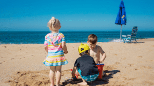 Kinderen op het strand met emmer en schepje tijdens een kindvriendelijke strandvakantie in Europa