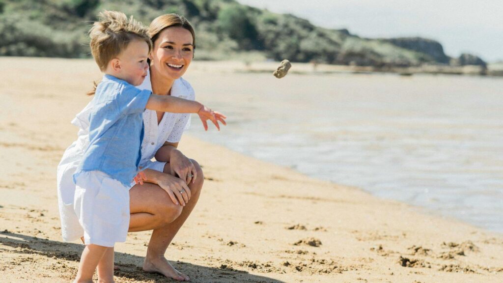 Moeder en kind lachen samen op tropisch strand in de Filipijnen