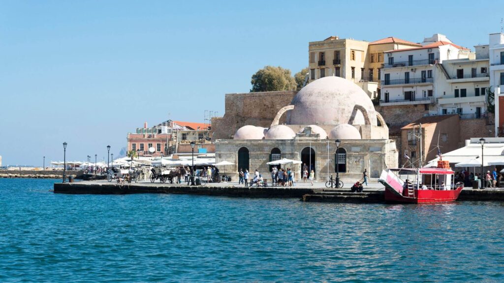 De Venetiaanse haven van Chania met kleurrijke huizen, bootjes en de iconische vuurtoren op Kreta  