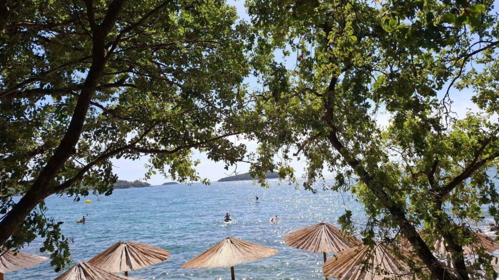 Genieten van zon en zee onder parasols aan de kust van Kroatië, symbool voor een goed gepland reisbudget.