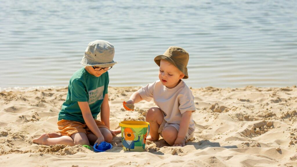 Gezin op strand tijdens een strandvakantie of bergvakantie – ontspanning aan zee