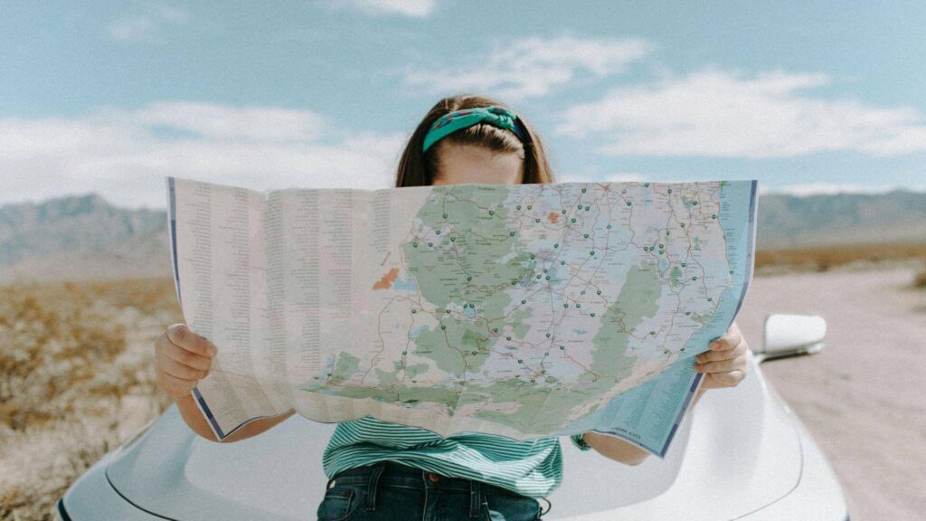 Solo reiziger met kaart onderweg tijdens een roadtrip in de natuur