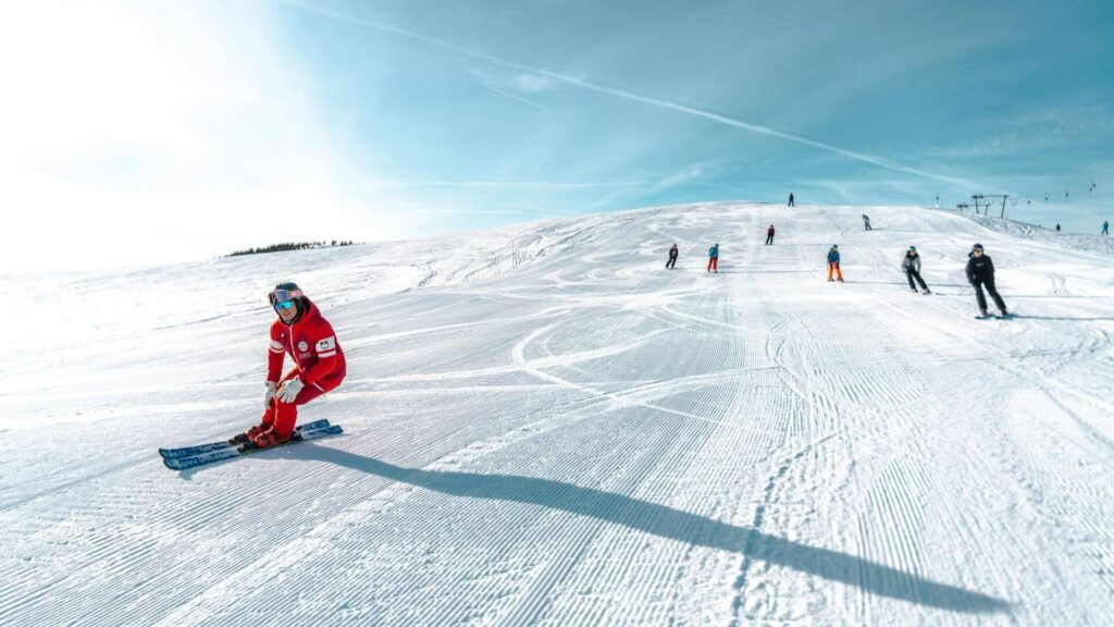 Skigebieden voor beginners 2025/2026: ski-instructeur geeft les aan beginners op blauwe piste