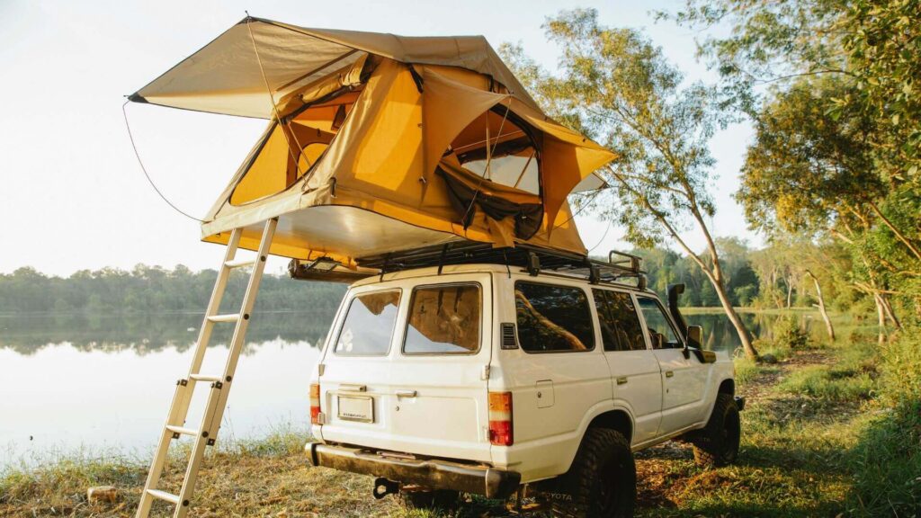 Auto met daktent geparkeerd in de natuur voor avontuur en vrijheid
