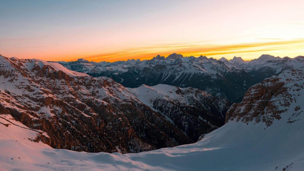 Skigebieden voor beginners 2025/2026: besneeuwde bergen bij zonsondergang