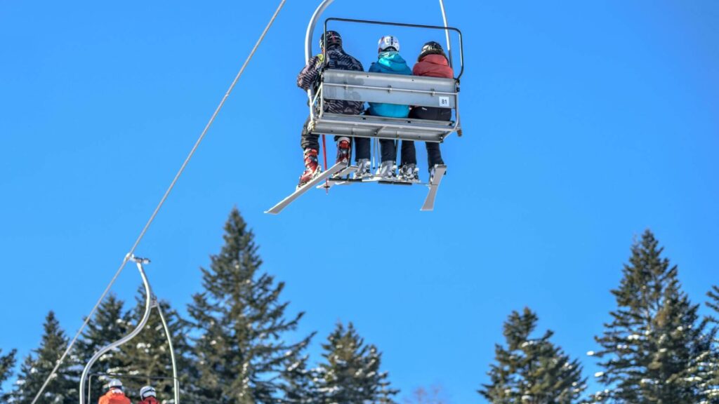 Mensen in een skilift met uitzicht op besneeuwde bergen tijdens de wintersport