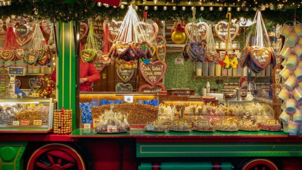 Kraam met kleurrijke peperkoekharten en gebrande amandelen op de kerstmarkt in Gent
