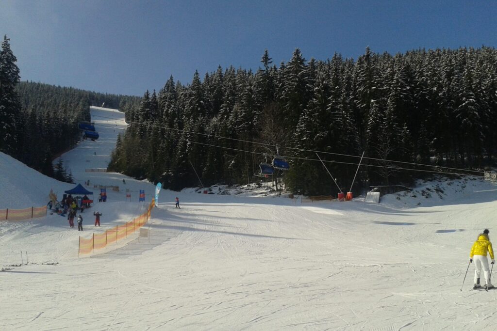 Beginnende skiër op een brede en rustige blauwe piste tijdens wintersport