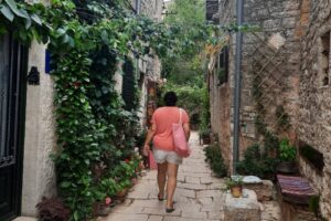 Solo reiziger loopt door smal straatje tijdens weekendje weg alleen in een Europese stad