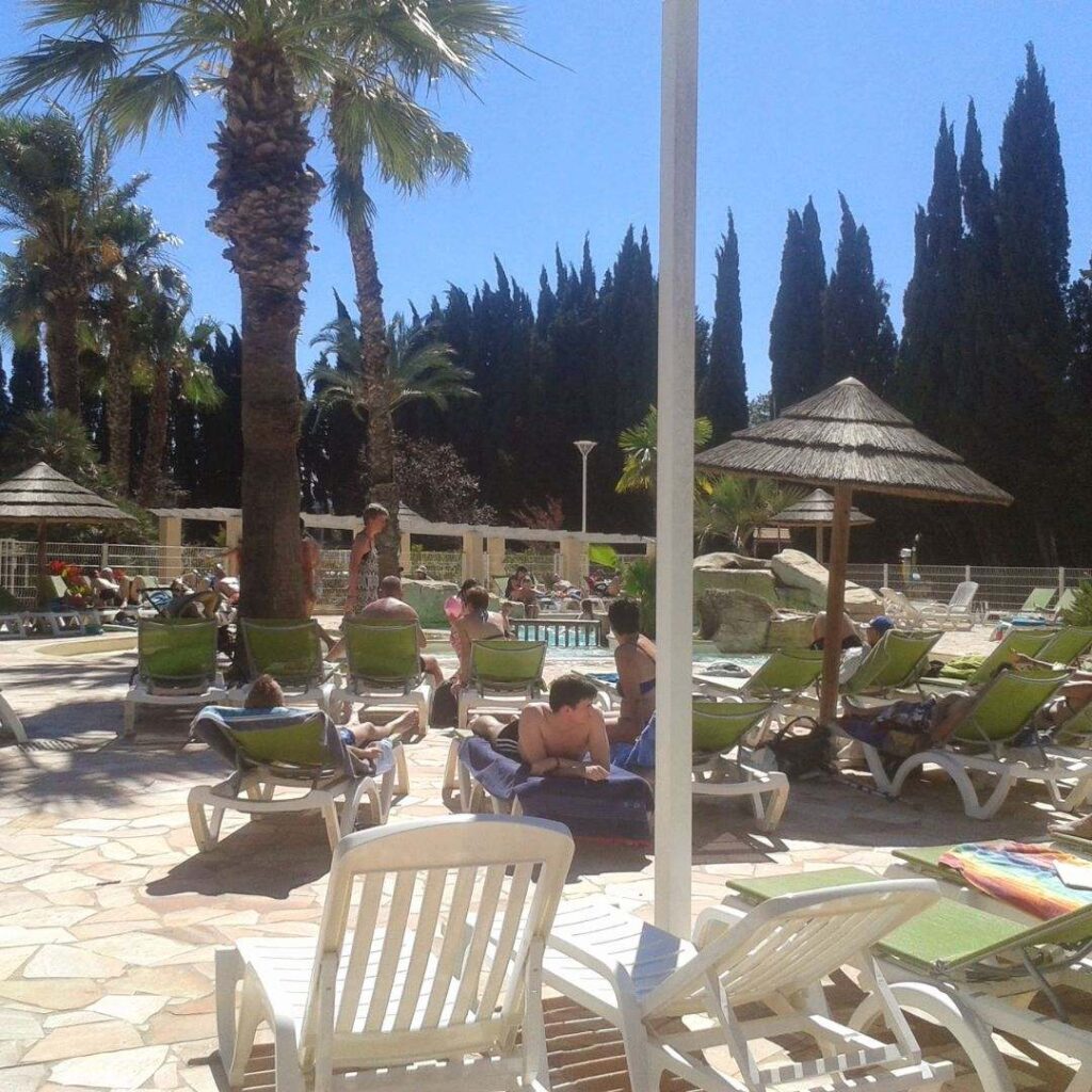 Zwembad op een camping aan het Gardameer met ligbedden en glijbaan