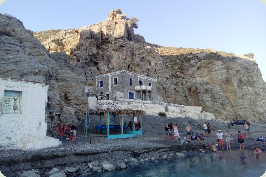 De indrukwekkende rotswanden en het stenen gebouw bij de Embros Thermen op Kos Griekenland
